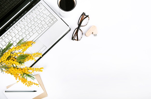 set festoso di primavera con fiori e un computer portatile su uno sfondo bianco