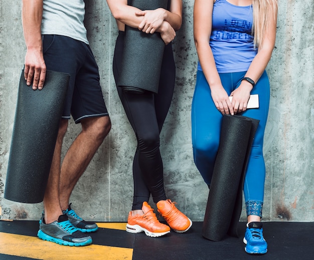 Sezione bassa vista delle persone con materassino in palestra