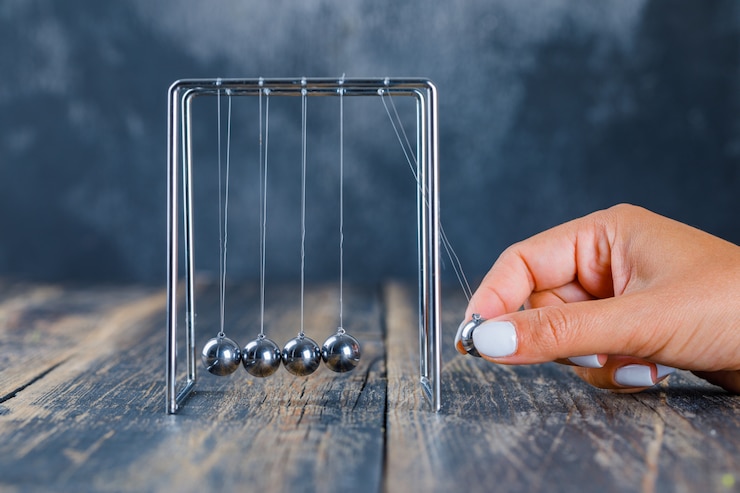 Foto gratuito sfera d'equilibratura della mano sulla culla di newton
