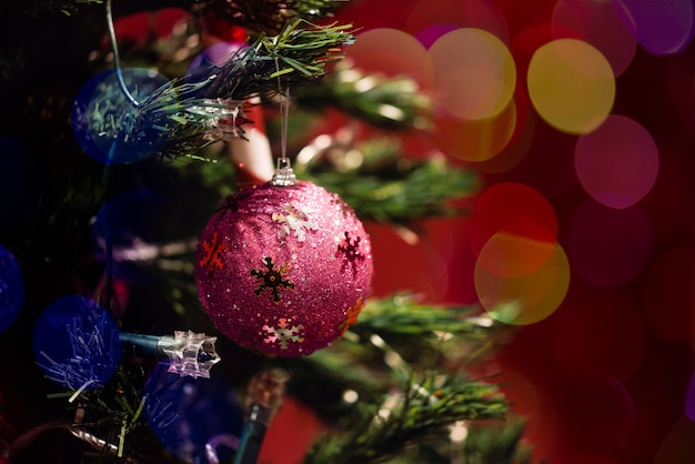 Sfera di natale in albero con bokeh su sfondo rosso