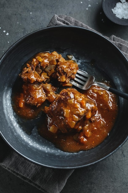 Sfera di stufato di manzo con sensazione di verdure in salsa su piatto scuro. Avvicinamento