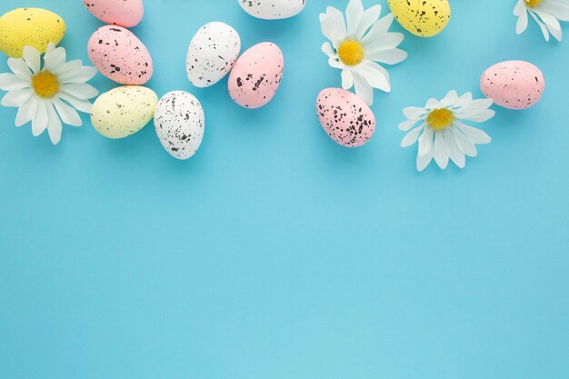 Sfondo di Pasqua con uova e margherite su sfondo blu con spazio di copia