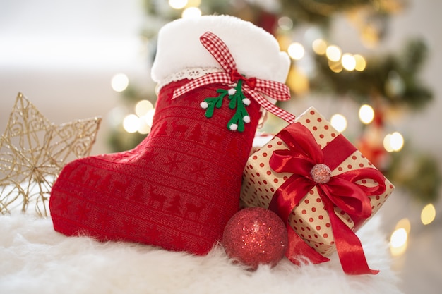 Sfondo di vacanze di Capodanno con un calzino decorativo e una confezione regalo in un'atmosfera accogliente da vicino.