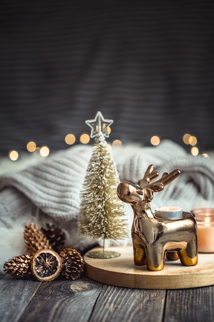 Sfondo festivo di Natale con cervi giocattolo, sfondo sfocato con luci dorate e candele
