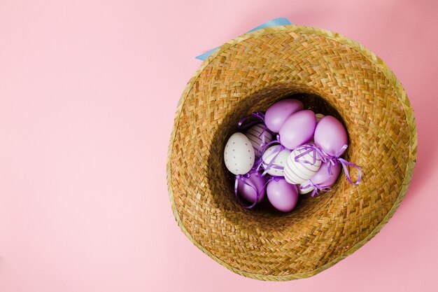 Sfondo rosa con cappello e uova di Pasqua