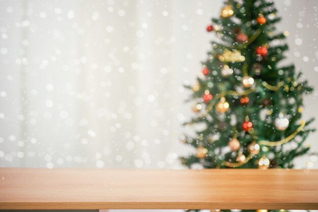 Sfondo vuoto della tavola di natale con l'albero di natale sfuocato per il montaggio dell'esposizione del prodotto