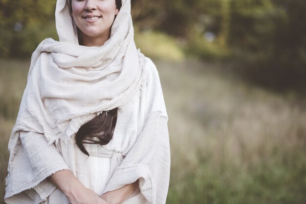 Shallow focus shot di una donna che indossa una veste biblica e sorridente