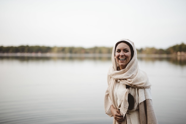 Shallow focus shot di una donna felice che indossa un abito biblico e sorridente