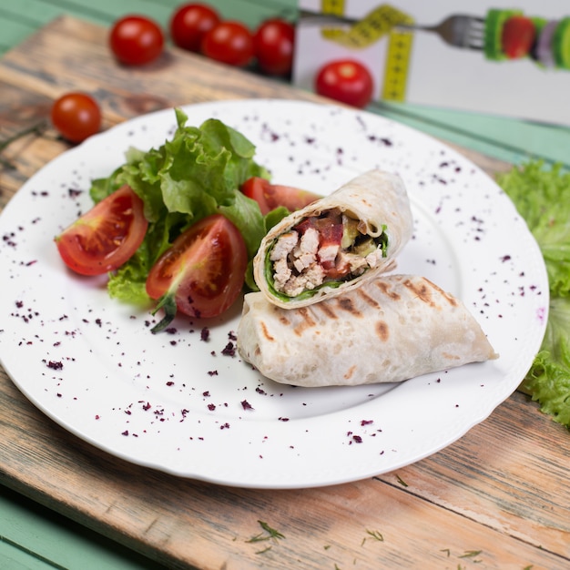 Shaurma arabo dell'alimento della via con insalata di verdure.