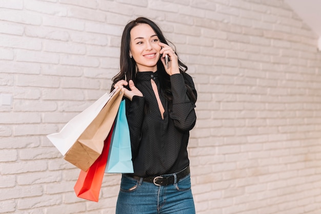 Shopper contemporaneo con borse che parlano al telefono