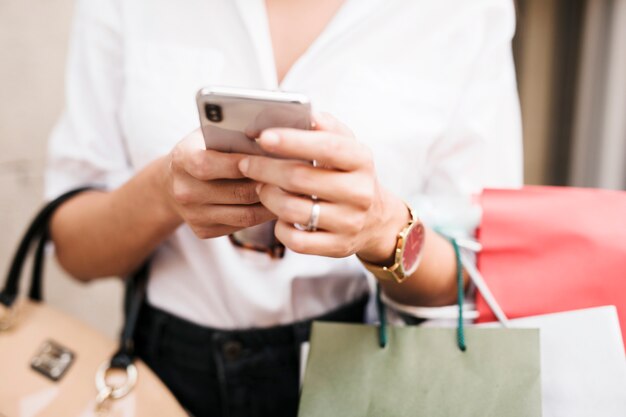 Shopping ragazza usando il suo telefono cellulare