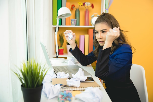 Signora allegra di affari che lavora al computer portatile in ufficio