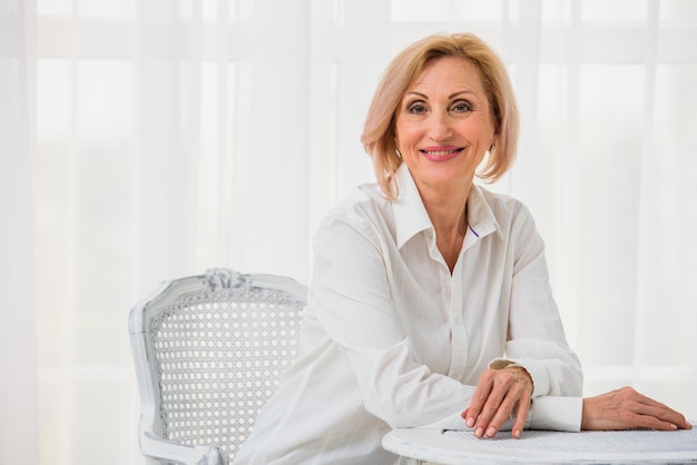 Signora anziana che posa mentre esaminando la macchina fotografica