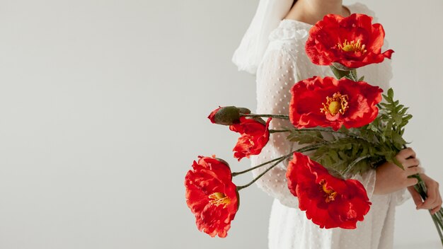 Signora che tiene lo spazio rosso della copia dei fiori