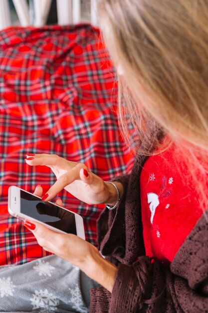 Signora che utilizza smartphone sul letto