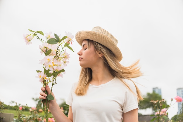 Signora con cappello con fiori bianchi