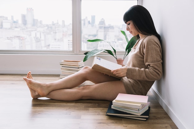 Signora con gli occhiali a leggere sul pavimento