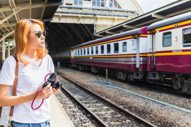 Signora con macchina fotografica sulla stazione ferroviaria