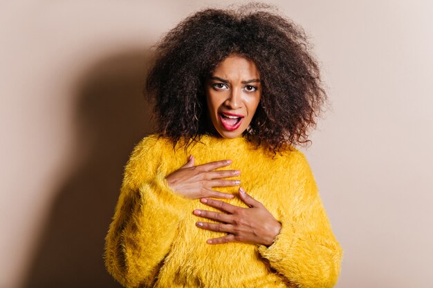 Signora delusa in maglione giallo che guarda al fronte