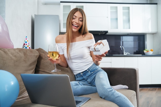 Signora di compleanno che ha una videochiamata sul laptop a casa