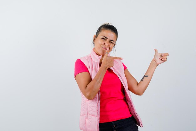 Signora in t-shirt, gilet che punta da parte e sembra sicura di sé