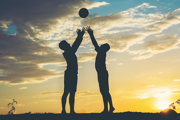 Silhouette di bambini giocano a calcio di calcio