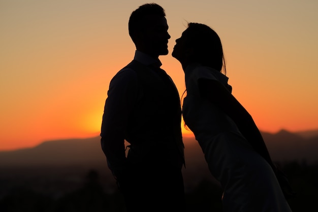 Silhouette di coppia di sposi al tramonto