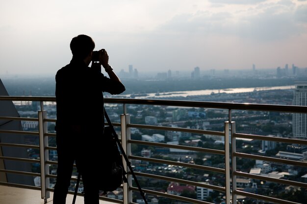 Silhouette uomo che prende la foto della città