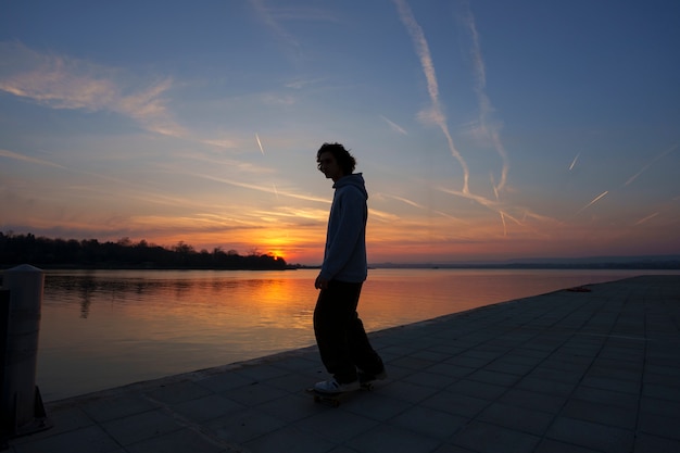 Siluetta dell'uomo del colpo pieno al tramonto