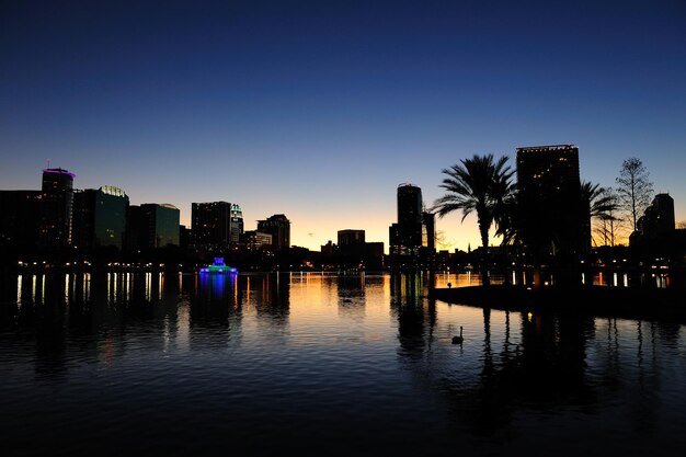 Siluetta di panorama dell'orizzonte del centro di Orlando sopra il lago Eola al crepuscolo con i grattacieli urbani.