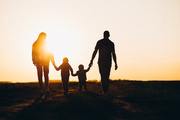 Siluetta felice della famiglia sul tramonto