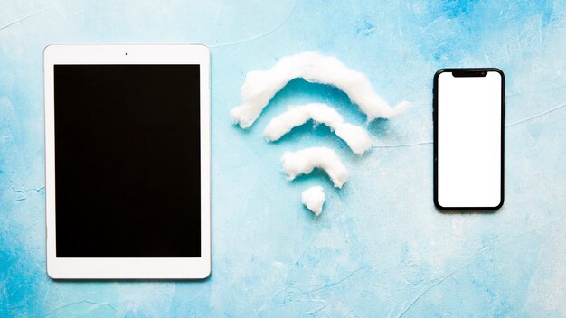 Simbolo di Wifi tra cellulare e tablet su sfondo blu