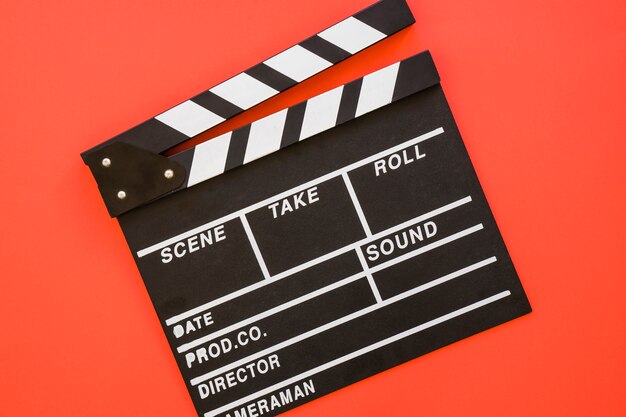 Singe clapperboard su sfondo rosso