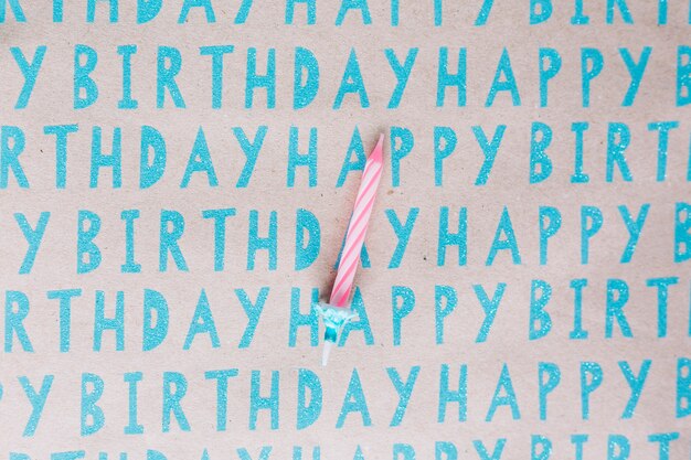 Singola candela a strisce su carta di buon compleanno