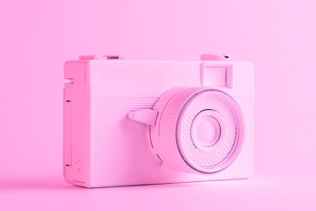 Singola macchina fotografica verniciata contro il contesto rosa colorato