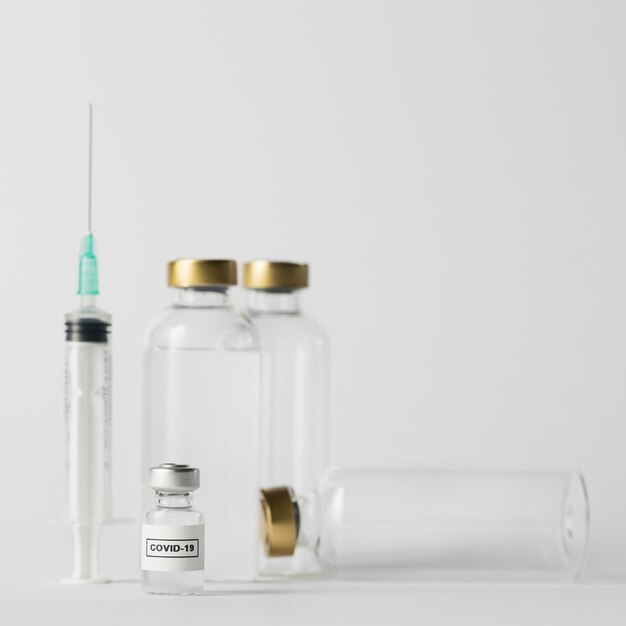 Siringa vista frontale e bottiglie di vaccino