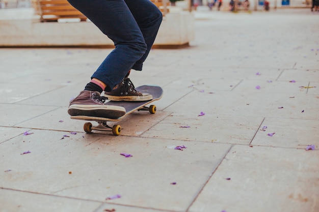 Skateboard teen riding sulla bandiera di pavimentazione