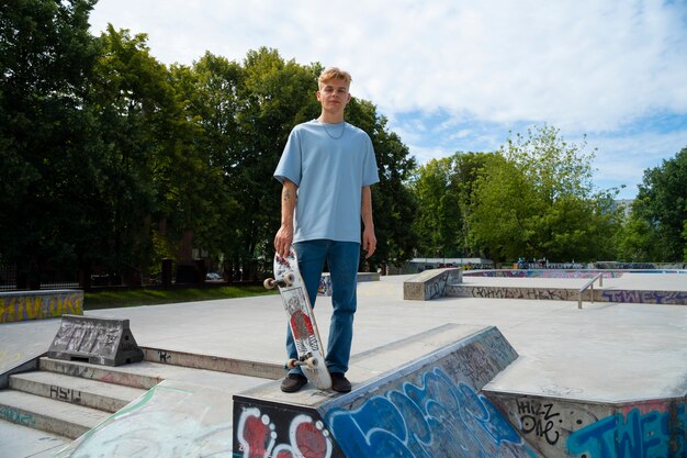 Skateboard teenager della tenuta di vista frontale