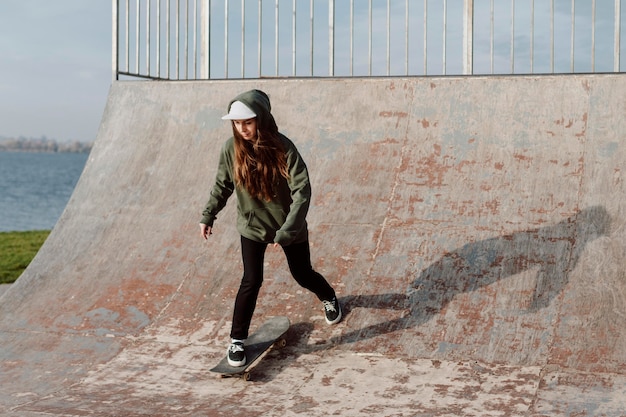 Skateboarder femminile che utilizza rampe per i trucchi