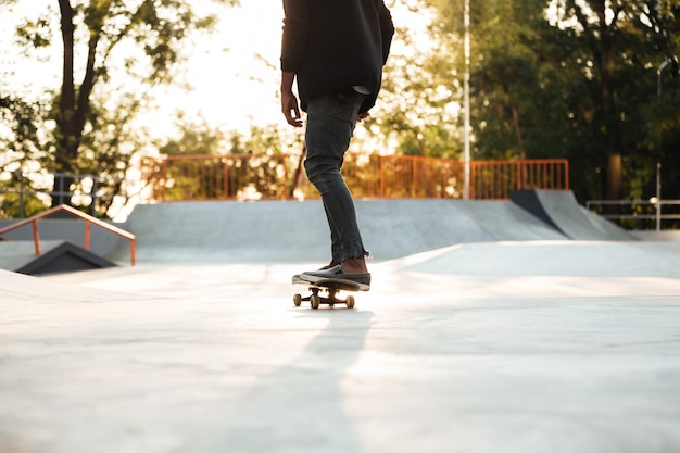 Skateboarder giovane su skateboard al parco cittadino