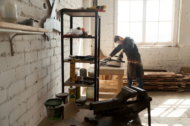 Skilled cabinet maker che lavora in piccola officina