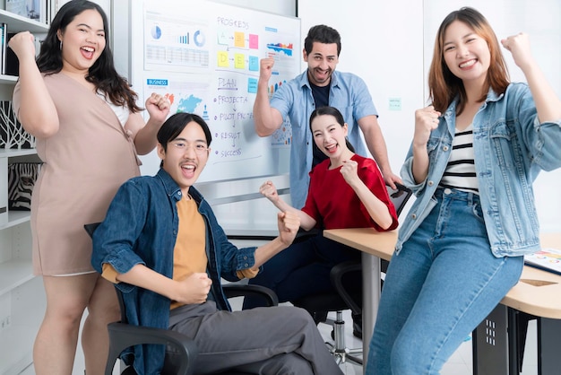 Smart Asian startup piccolo imprenditore in piedi ritratto fiducioso con amici partner incontro casuale brainstorming con lavagna bianca e analisi del grafico cartaceo finanziario aziendale in background dell'ufficio