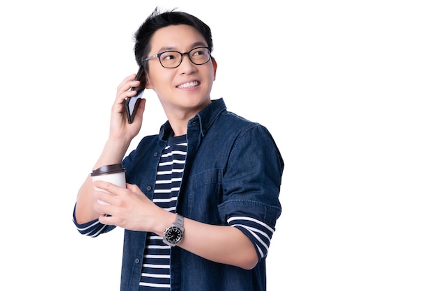 Smart attraente asiatico occhiali maschio mano tenere bevanda calda caffè con freschezza e gioioso abito casual ritratto sfondo bianco comunicazione a mano con smartphone