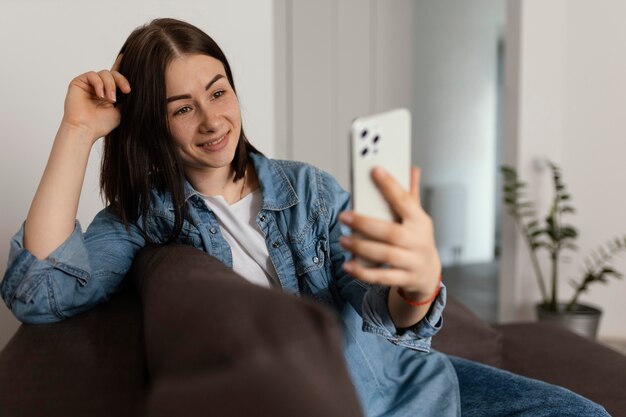 Smartphone della holding della donna di smiley del colpo medio