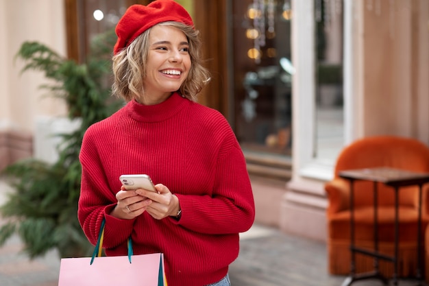 Smartphone della holding della donna di smiley del colpo medio