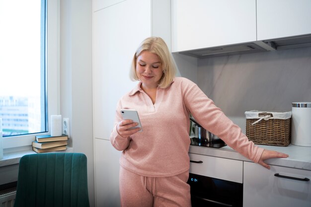 Smartphone della tenuta della donna di vista frontale