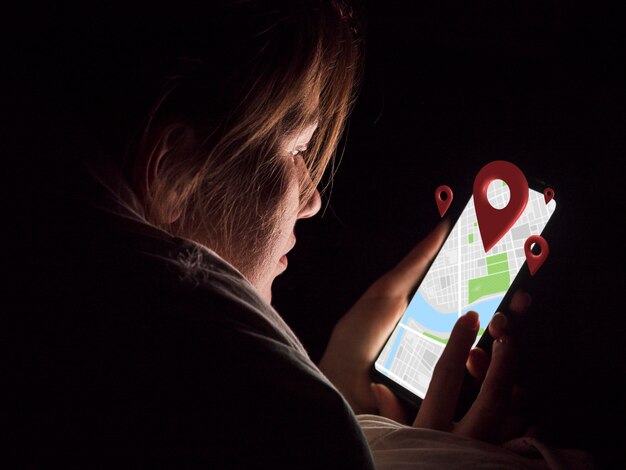 Smartphone della tenuta della donna di vista laterale
