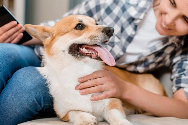 Smartphone della tenuta della donna ed esaminare il suo cane