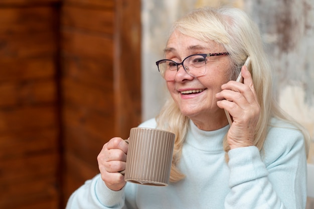 Smile di angolo basso femminile parlando al telefono