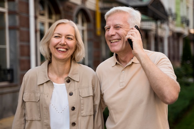 Smiley coppia senior all'aperto durante l'assunzione di smartphone